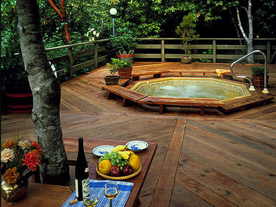Redwood decking applied in a herring bone pattern surround an octagonal spa.