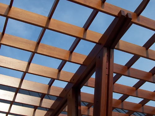 A shade structure made from redwood timbers and boards.