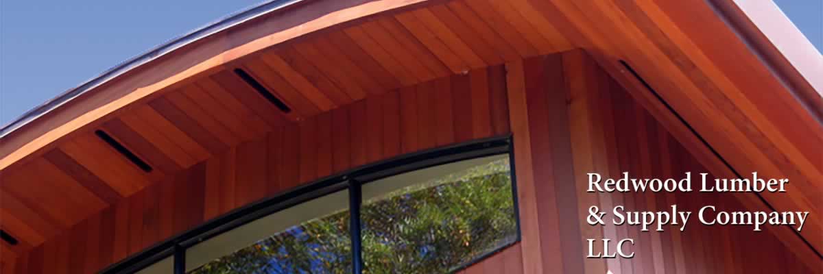A modern house with a curved roof with redwood siding and soffits.