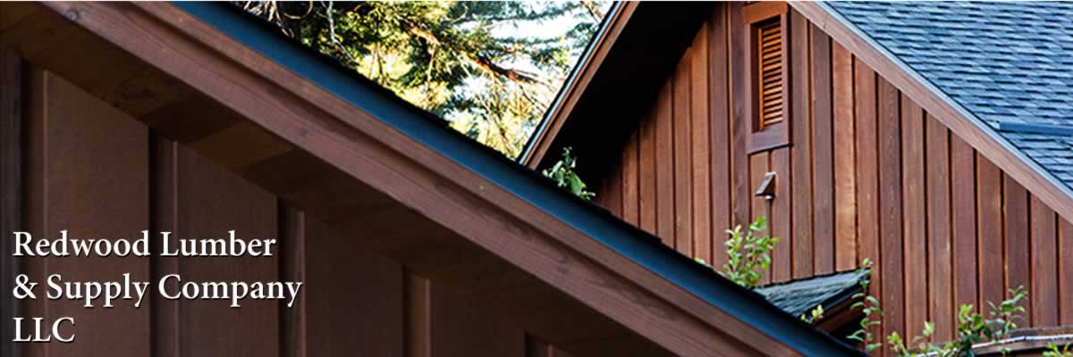 A custom house has beautiful redwood siding and soffits. The house also features custom-designed, curved windows.