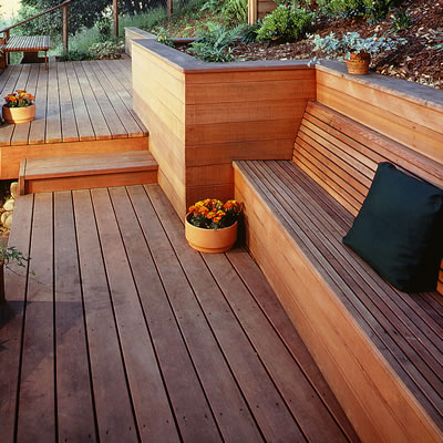 A modern redwood deck's design includes multi-levels, builtin planters, retaining walls and benches.